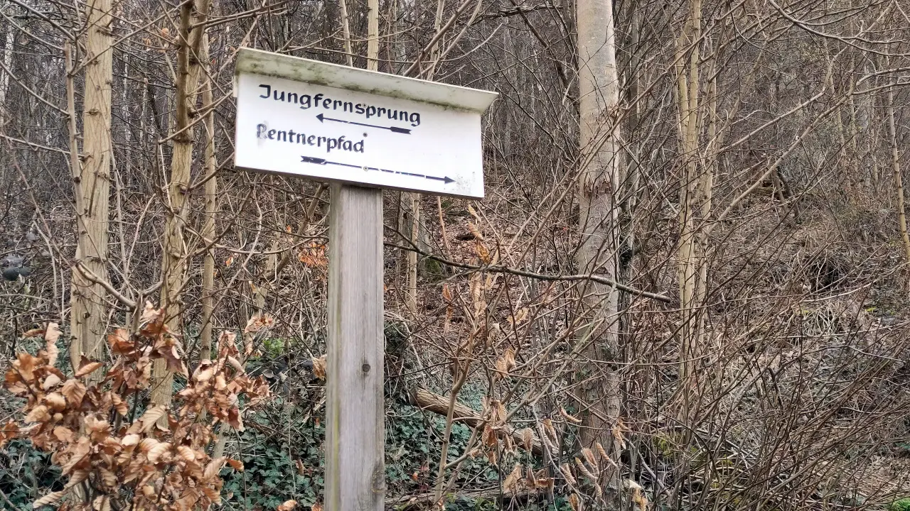 A sign with "Jungfernsprung" (maiden's jump) to the left und "Rentnerpfad" (pensioner's path) to the right