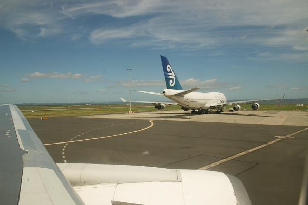 Blick aus dem Flugzeugfenster auf dem Rollfeld. Ein anderes Flugzeug ist von hinten zu sehen.