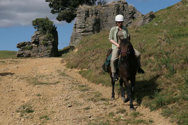 Manu auf einem Pferd vor Felsen