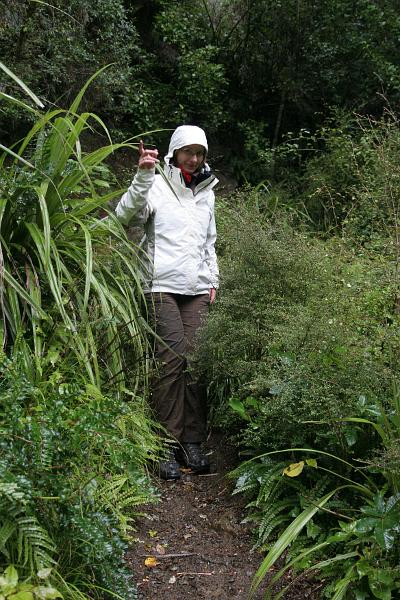 Manu in Regenklamotten zeigt nach oben