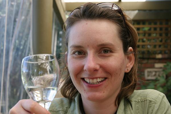Portait von Manu mit einem Glas Weißwein in der Hand