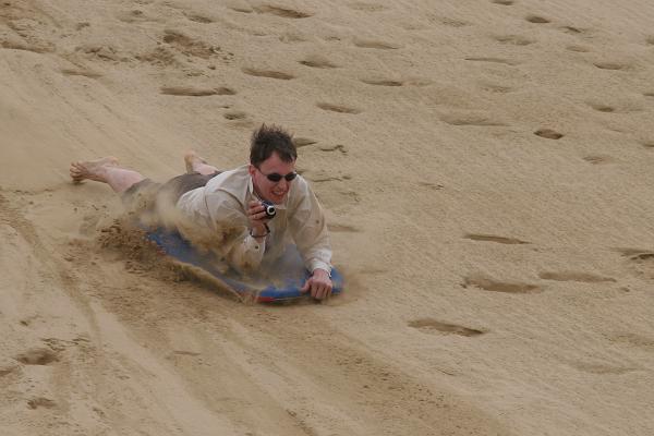 Markus mit Kamera in der Hand auf dem Sandboard