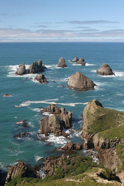 Vereinzelnte Felsen wie Goldnuggets im blauen Meer