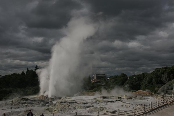 Ein ausbrechender Geysir vor dunklen Wolken