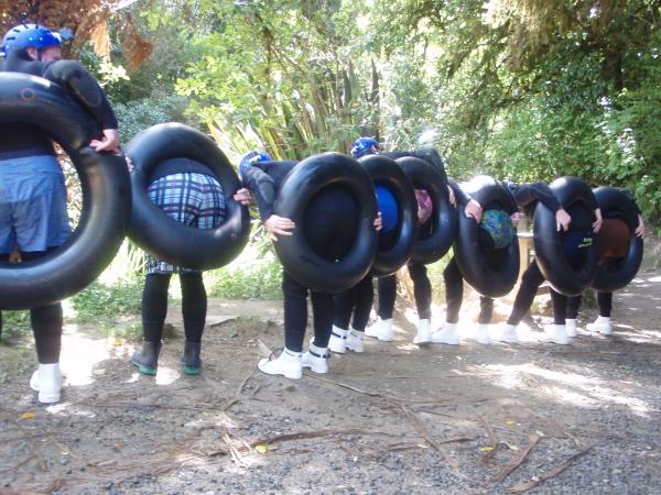 Eine Reihe von Leuten, nach vorn gebeugt, mit Reifen am Hintern