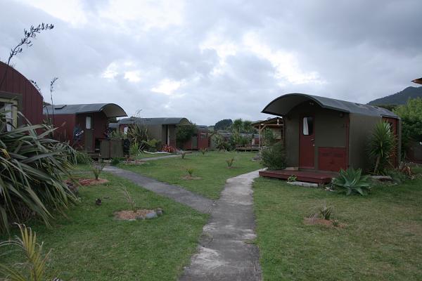 Eine Wiese mit zu kleinen Hütten umgebauten Wagons