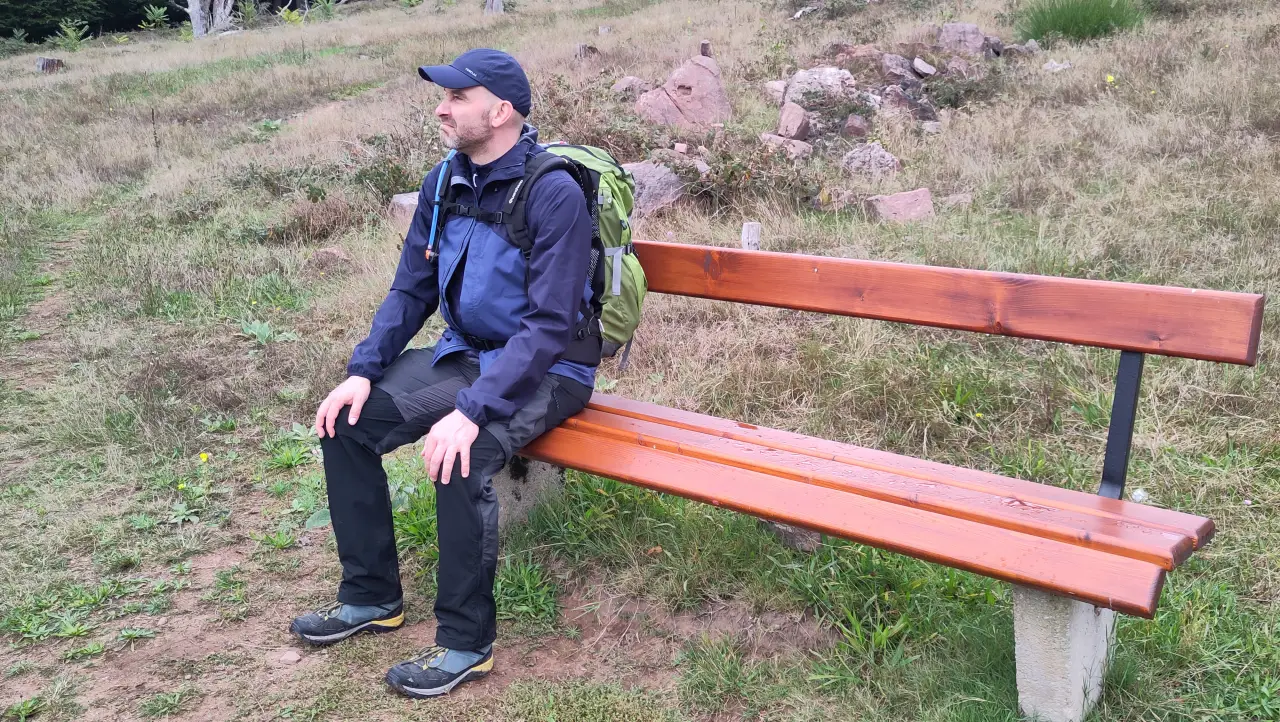 Marcus sitzt mit verkniffenem Gesicht auf einer Bank und geniest den Ausblick ganz offenbar nicht.