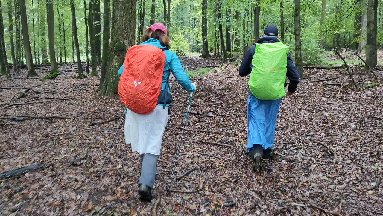Marcus und Manu eingepackt in bunte Regenklamotten im Wald
