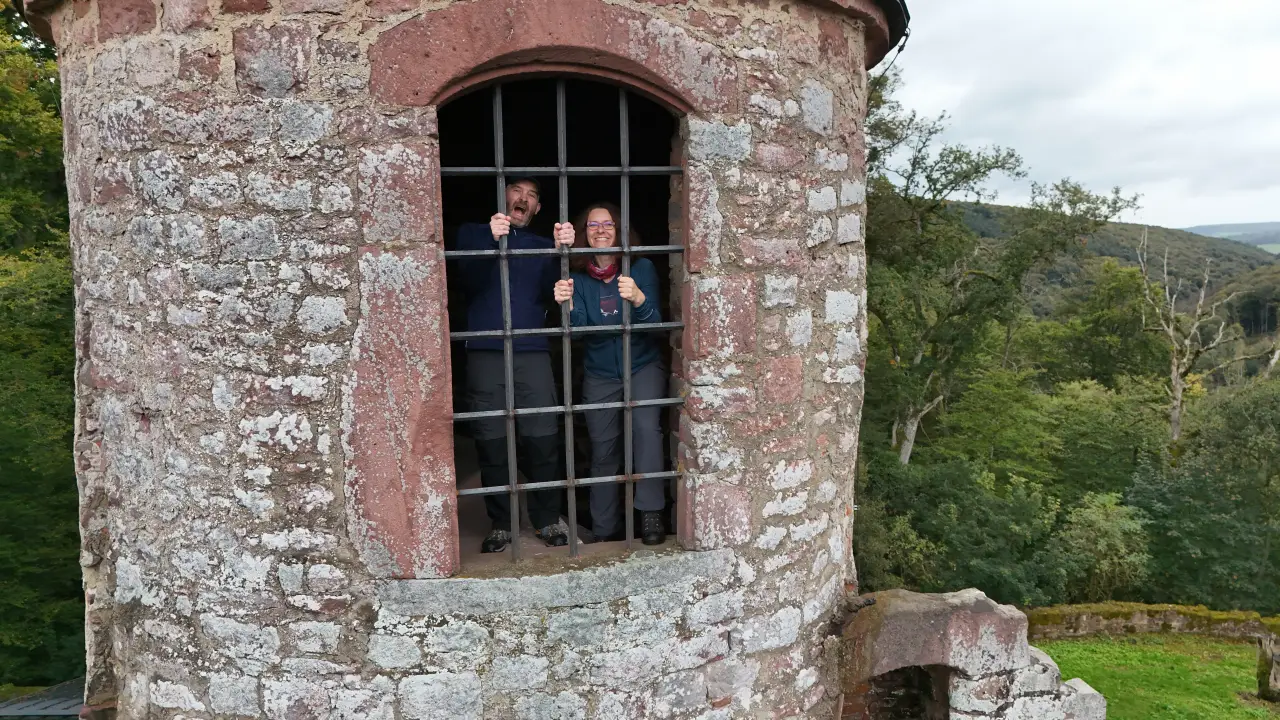 Manu und Marcus im Turm der Ruine Schönrain hinter Gittern. Das Foto wurde von der Drohne von außen vor dem Turm schwebend aufgenommen